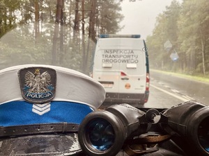 zdjęcie przedstawia policjanta i funkcjonariusza inspekcji transportu drogowego przy pojazdach