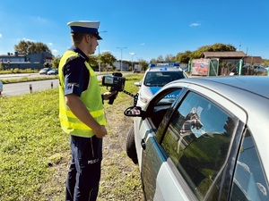 zdjęcie przedstawia policjanta w trakcie kontroli drogowej