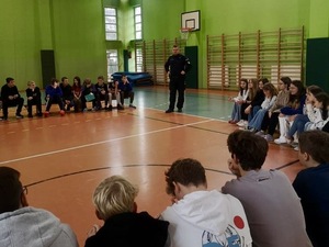 zdjęcie przedstawia policjanta w trakcie prelekcji z uczniami