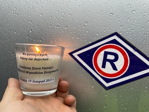 zdjęcie przedstawia zbliżenie na świeczkę i logo ruchu drogowego