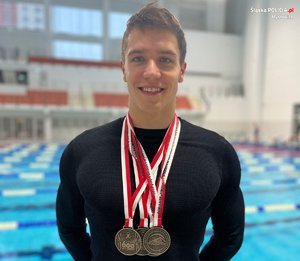 zdjęcie przedstawia mężczyznę z medalami na szyi