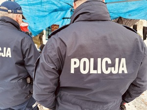 zdjęcie przedstawia zbliżenie na napis POLICJA na plecach policjanta