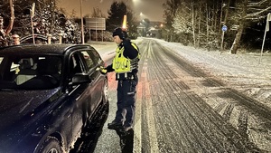 zdjęcie przedstawia policjanta w trakcie kontroli drogowej