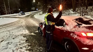 zdjęcie przedstawia policjanta w trakcie kontroli drogowej