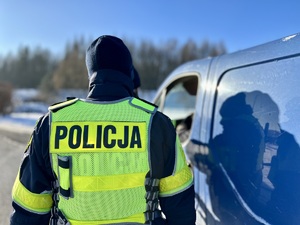 zdjęcie przedstawia policjanta w trakcie kontroli drogowej