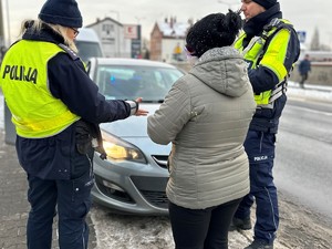 zdjęcie przedstawia policjantów w trakcie kontroli drogowej