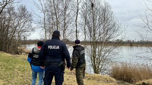 zdjęcie przedstawia policjanta wraz z przedstawicielami straży rybackiej