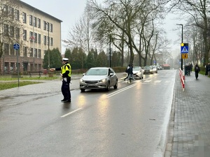 zdjęcie przedstawia policjanta zatrzymującego pojazd do kontroli