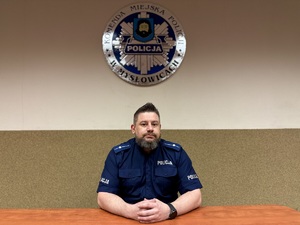 zdjęcie przedstawia policjanta przy biurku