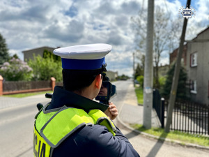 zdjęcie przedstawia policjantów w trakcie pomiaru prędkości pojazdów