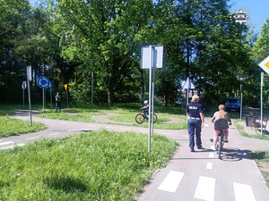 zdjęcie przedstawia policjanta i dziecko na rowerze w trakcie egzaminu na kartę rowerową