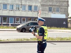 zdjęcie przedstawia policjanta w trakcie kontroli drogowej