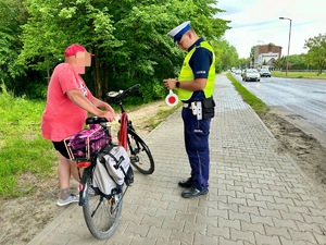 zdjęcie przedstawia policjantów w trakcie kontroli rowerzysty