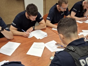 Na zdjęciu widoczni policjanci rozwiązujący test