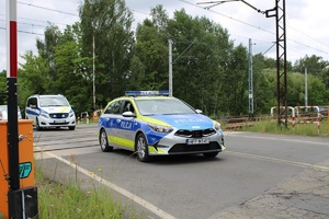 zdjęcie przedstawia policjantów w radiowozie zabezpieczających przejazd motocyklistów