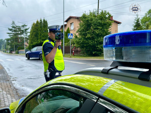 zdjęcie przedstawia policjanta w trakcie kontroli drogowej