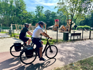 zdjęcie przedstawia policjanta i strażnika miejskiego na rowerach.