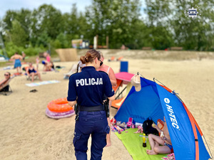 zdjęcie przedstawia policjantów w trakcie rozmowy z plażowiczami