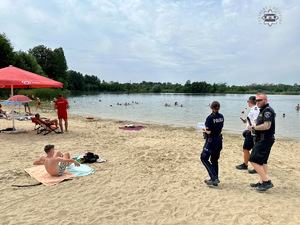 zdjęcie przedstawia policjantów w trakcie rozmowy z plażowiczami