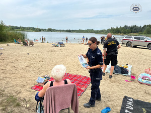 zdjęcie przedstawia policjantów w trakcie rozmowy z plażowiczami