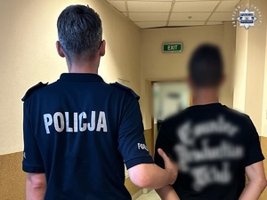 zdjęcie przedstawia sprawcę prowadzonego przez policjanta