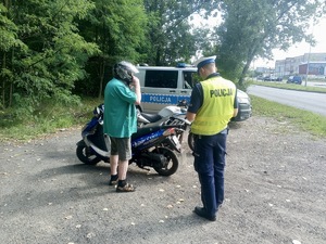 zdjęcie przedstawia policjantrów w trakcie kontroli drogowej motocyklisty