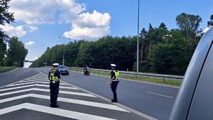 zdjęcie przedstawia policjantrów w trakcie kontroli drogowej motocyklisty