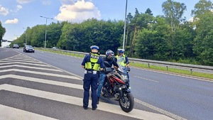 zdjęcie przedstawia policjantrów w trakcie kontroli drogowej motocyklisty