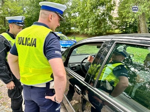 zdjęcie przedstawia policjantów w trakcie kontroli drogowej