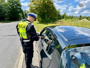 zdjęcie przedstawia policjantów w trakcie kontroli drogowej