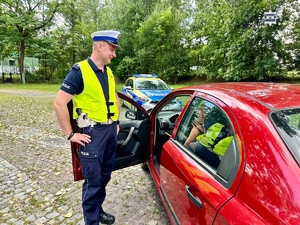 zdjęcie przedstawia policjantów w trakcie kontroli drogowej