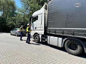 zdjęcie przedstawia policjantów w trakcie kontroli samochodu ciężarowego