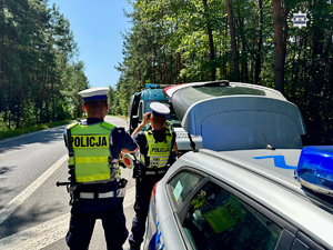 zdjęcie przedstawia policjantów w trakcie kontroli samochodu ciężarowego