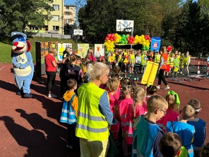 zdjęcie przedstawia policjantów i dzieci zgromadzone na boisku szkolnym