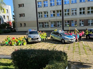 zdjęcie przedstawia policjantów i dzieci zgromadzone na boisku szkolnym