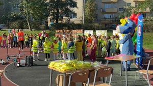 zdjęcie przedstawia policjantów i dzieci zgromadzone na boisku szkolnym