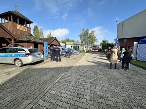 zdjęcie przedstawia policjantów w trakcie pikniku prezentujących radiowóz.