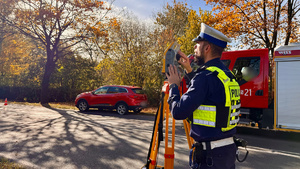 zdjęcie przedstawia policjantów w trakcie czynności na miejscu wypadku drogowego