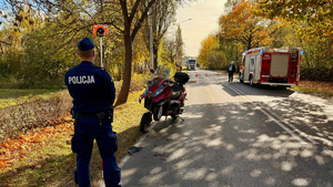 zdjęcie przedstawia policjantów w trakcie czynności na miejscu wypadku drogowego