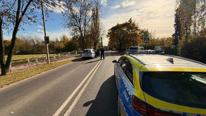 zdjęcie przedstawia policjantów w trakcie czynności na miejscu wypadku drogowego