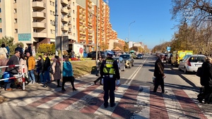 Zdjęcie przedstawia policjantów w trakcie kontroli ruchu w rejonie cmentarzy