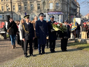 zdjęcie przedstawia przedstawicieli służb mundurowych składających wieńce pod miejscami pamięci.