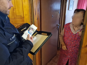 zdjęcie przedstawia policjanta przekazującego ulotki mieszkańcom