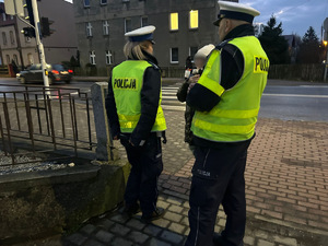 zdjęcie przedstawia policjantów rozdających odblaski przechodniom