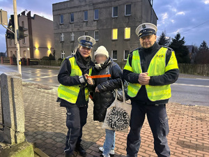 zdjęcie przedstawia policjantów rozdających odblaski przechodniom