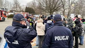 zdjęcie przedstawia policjantów rozdających elementy odblaskowe