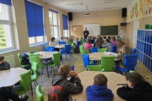 zdjęcie przedstawia policjanta w trakcie prelekcji dla dzieci