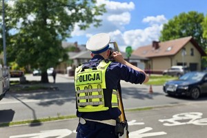 zdjęcie przedstawia policjantów wykonujących czynności na miejscu wypadku drogowego z udziałem motocykla.