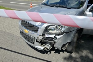 zdjęcie przedstawia policjantów wykonujących czynności na miejscu wypadku drogowego z udziałem motocykla.