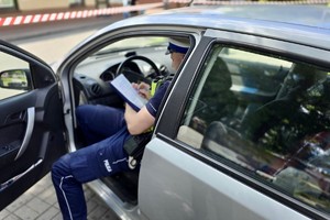 zdjęcie przedstawia policjantów wykonujących czynności na miejscu wypadku drogowego z udziałem motocykla.